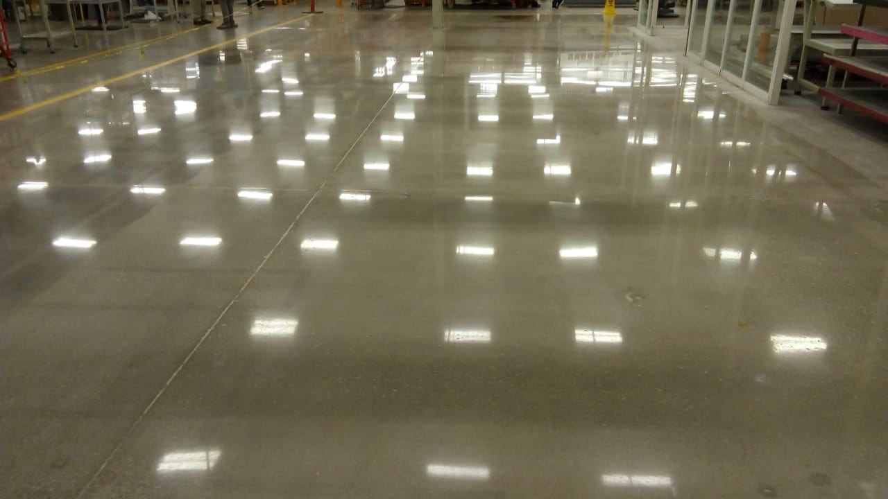 Concreto pulido espejo reflejando las luminarias de la bodega